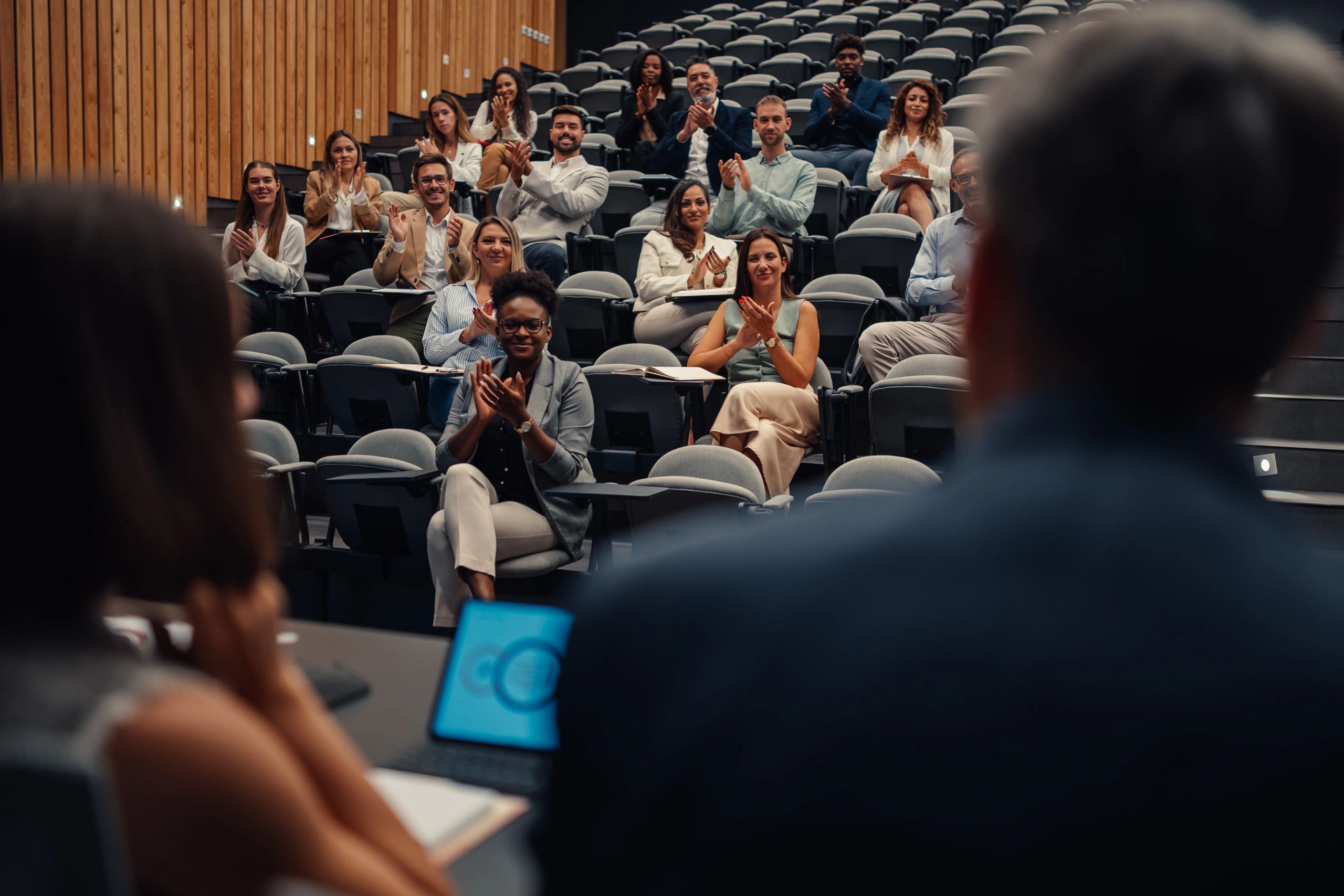 Audience at an education conference applauding during a presentation